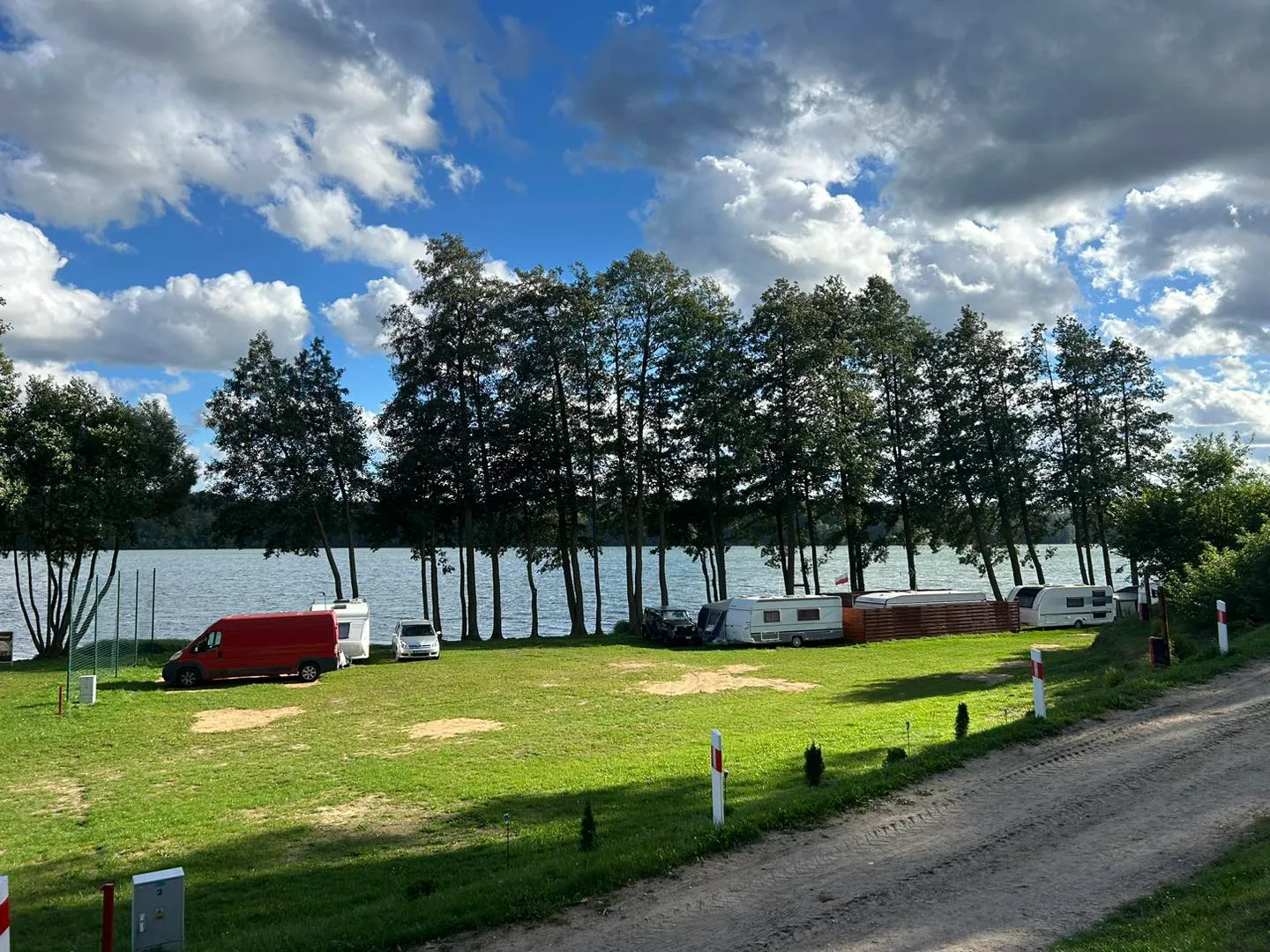 Widok na stanowiska campingowe z jeziorem