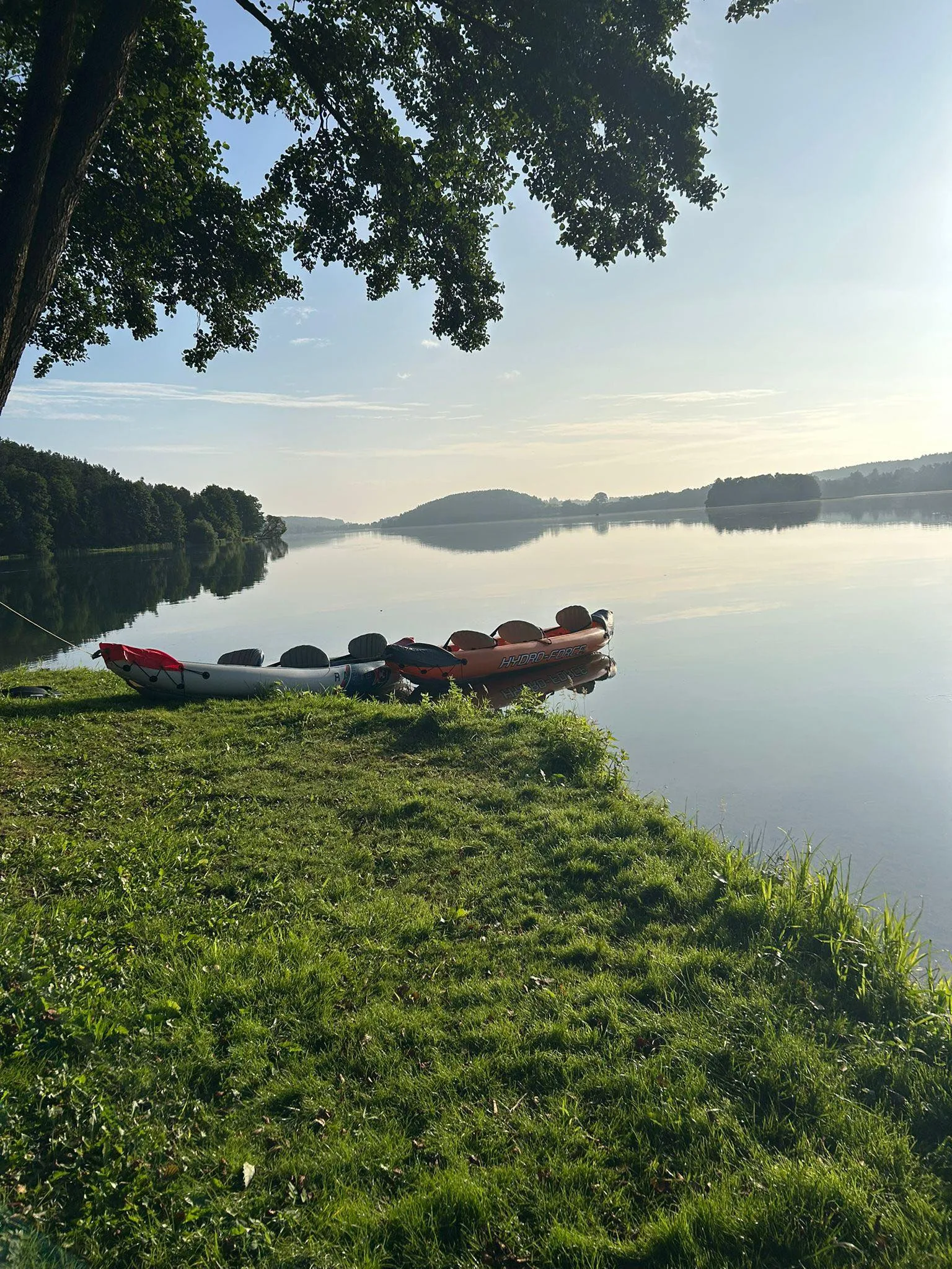Poranny spokój nad jeziorem z kajakami