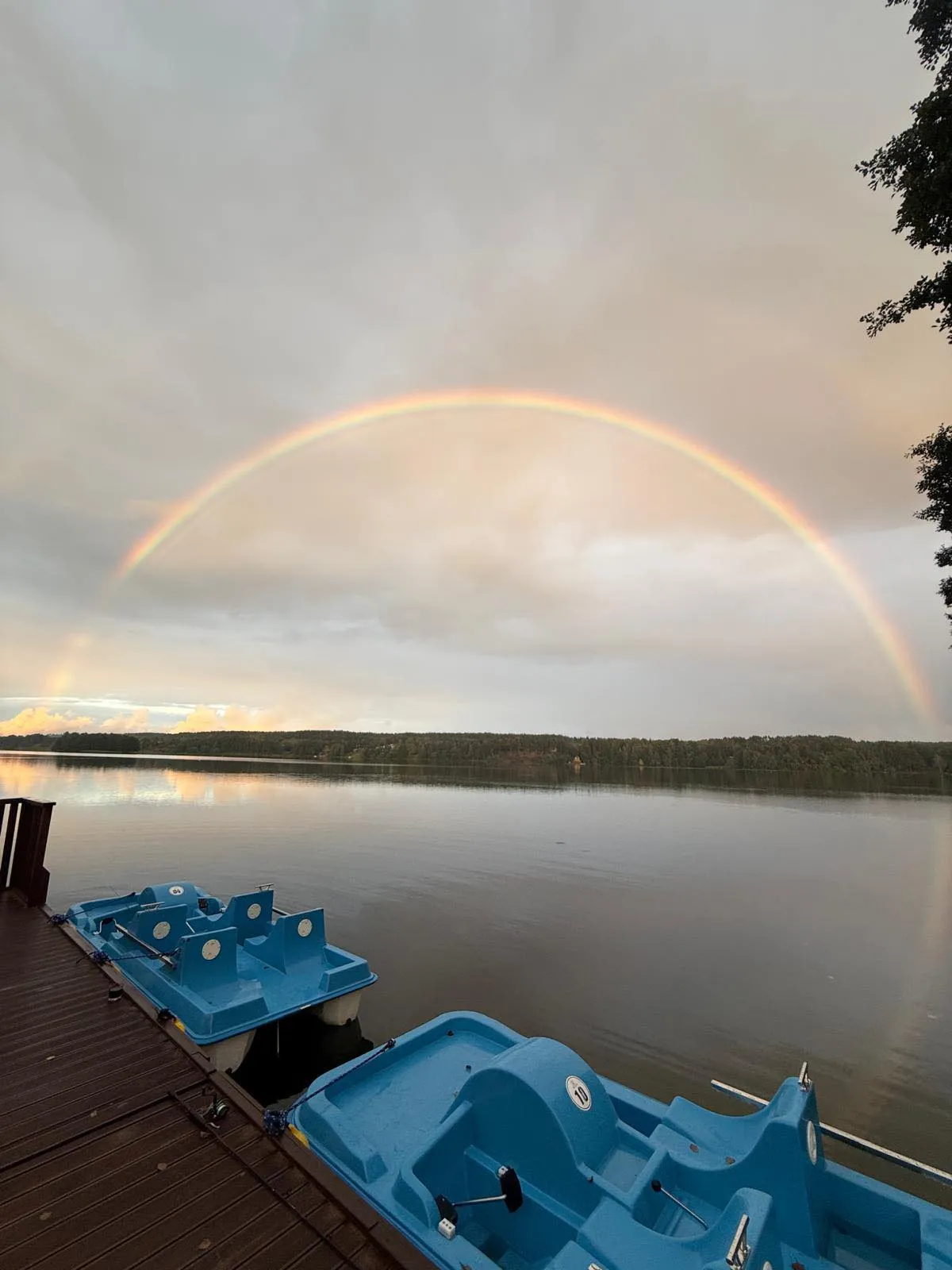 Tęcza nad jeziorem z rowerkami wodnymi